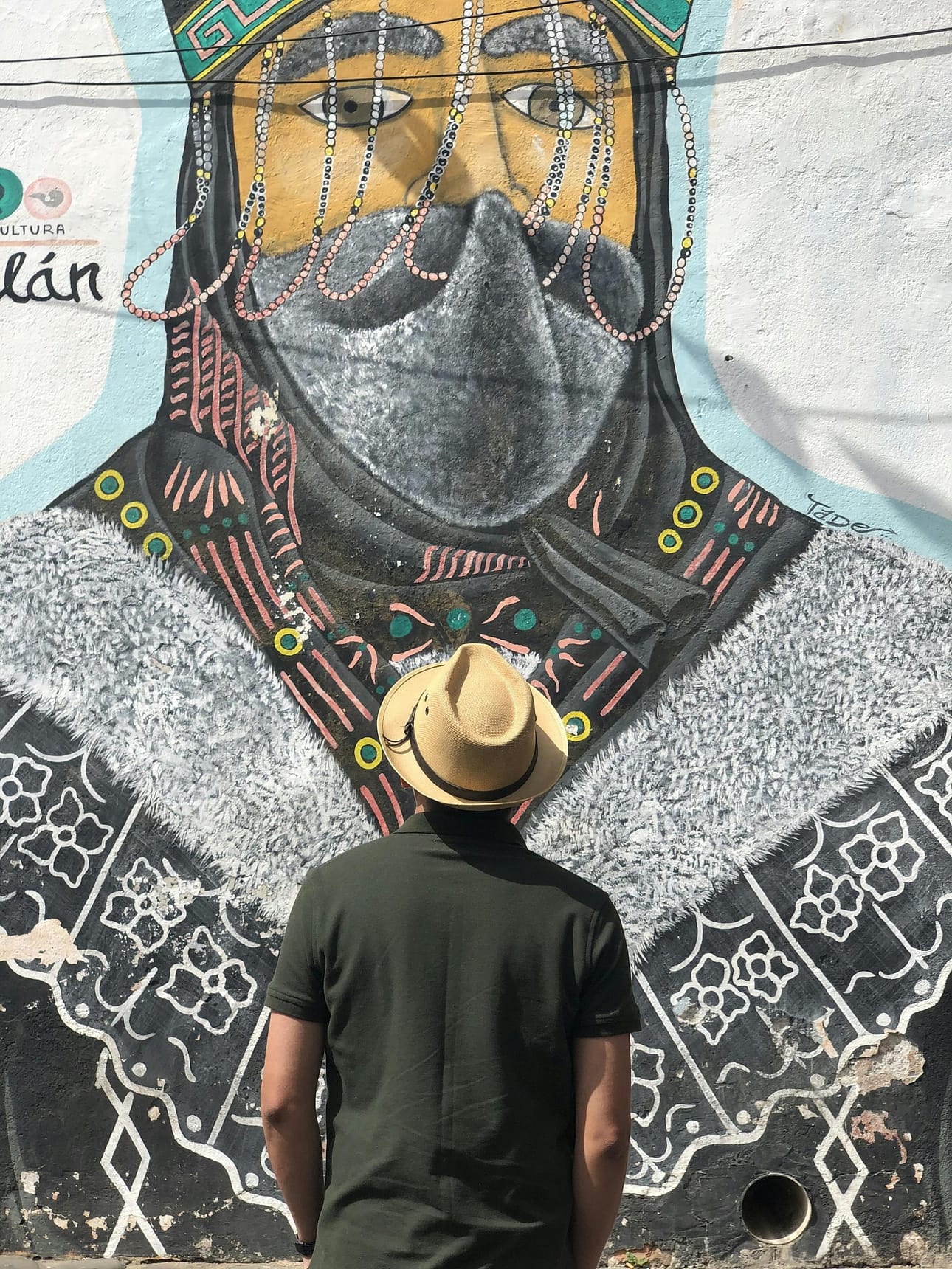 Perfect Places to Avoid the Crowds: Tepoztlán, Mexico 10 a person stands before a vibrant mural in tepoztlan mexico capturing local artistry. 12169588 scaled