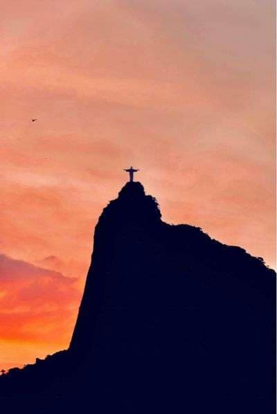 Jet Set LatAM 26 Silhouette of Christ the Redeemer statue on Corcovado Mountain in Rio de Janeiro at sunset